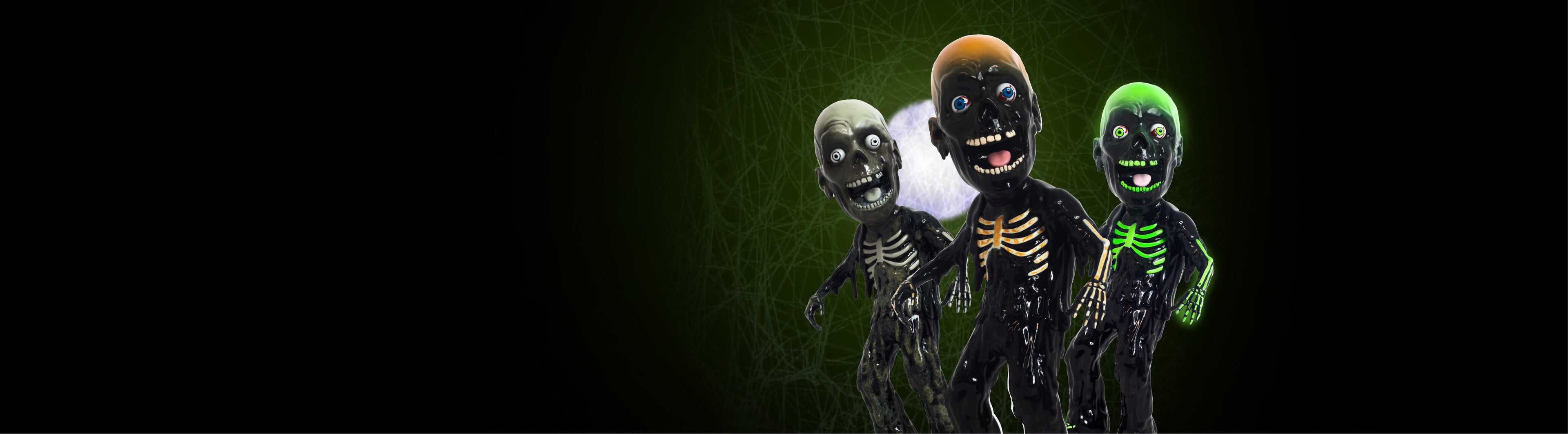 Three Tarman Bigheadz figures in normal, black & white, and green glow-in-the-dark colors, set against a dark green background with a full white moon. 