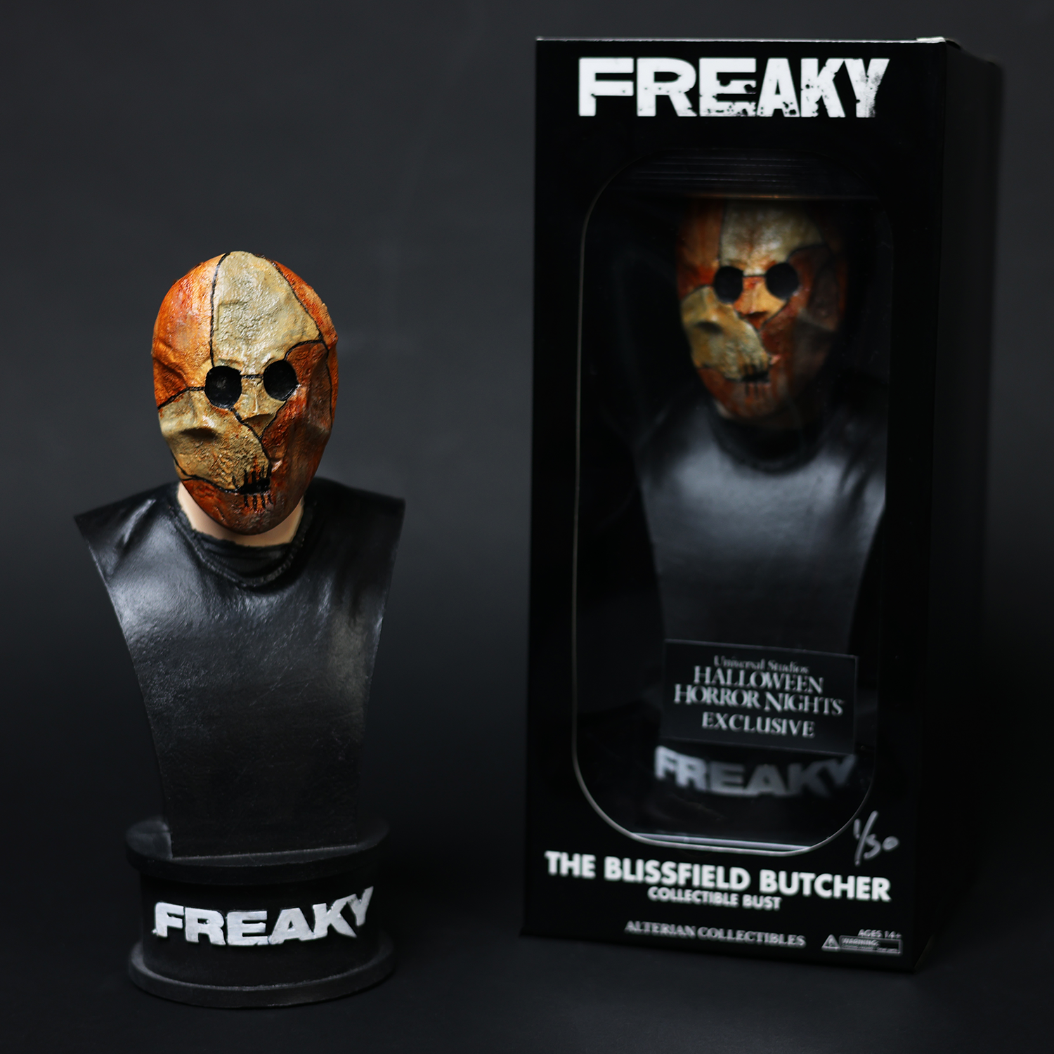 Front view of the Butcher Bust figure displayed with a packaged figure to its right.